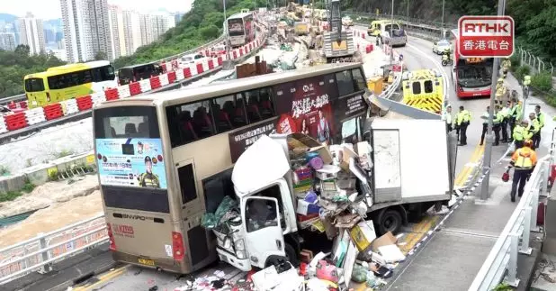 巴士車頭嚴重損毀，貨車的貨架被撞毀，現場一批發泡膠箱等雜物散落一地。（施華駿攝）