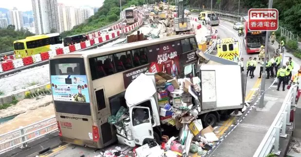 巴士車頭嚴重損毀，貨車的貨架被撞毀，現場一批發泡膠箱等雜物散落一地。（施華駿攝）