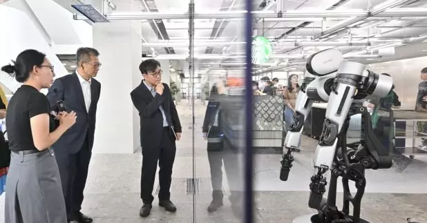 陳茂波參訪南韓創科企業，觀看企業在人工智能和機器人的應用展示。(政府新聞處圖片)