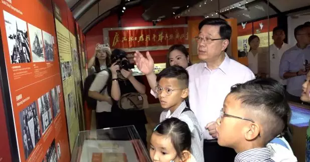 行政長官李家超中午到正舉辦抗戰勝利80周年主題展覽的香港抗戰及海防博物館與學生交流。(政府新聞處片段截圖)
