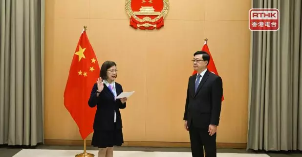 謝小華（左）在李家超（右）監誓下宣誓就任。（政府新聞處）