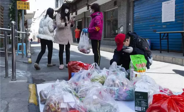 3月15日，湖北省襄陽市水星台社區黨委書記劉曉琳（右二）和社區工作人員在查看、分發居民從網上訂購的生活用品。新華網圖片