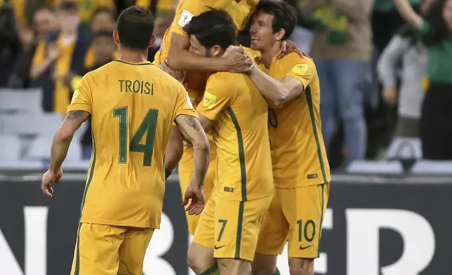 Australia's Tim Cahill, tops, celebrates with teammates after scoring against Syria during their Soccer World Cup qualifying match in Sydney, Australia, Tuesday, Oct. 10, 2017. (AP Photo/Rick Rycroft)