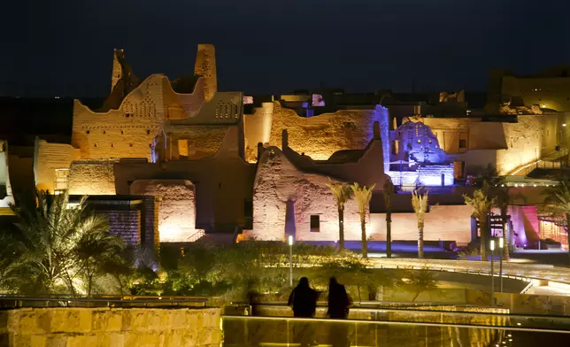 In this March 8, 2018 photo, visitors watch ancient palaces of the 18th century Diriyah fortified complex, that once served as the seat of power for the ruling Al Saud, in Riyadh, Saudi Arabia. (AP Photo/Amr Nabil)