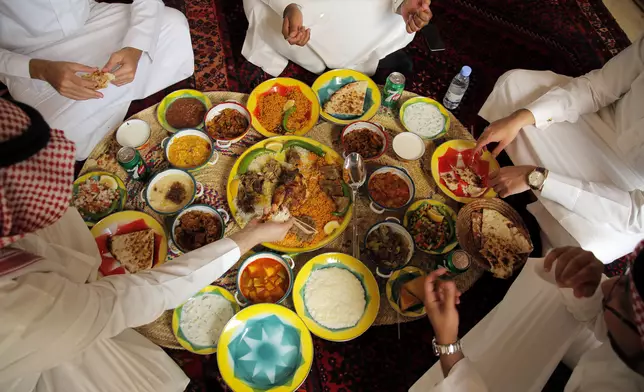 In this March 8, 2018 photo, holiday makers eat traditional Saudi food at a restaurant in the18th century Diriyah fortified complex, that once served as the seat of power for the ruling Al Saud family, in Riyadh, Saudi Arabia. (AP Photo/Amr Nabil)