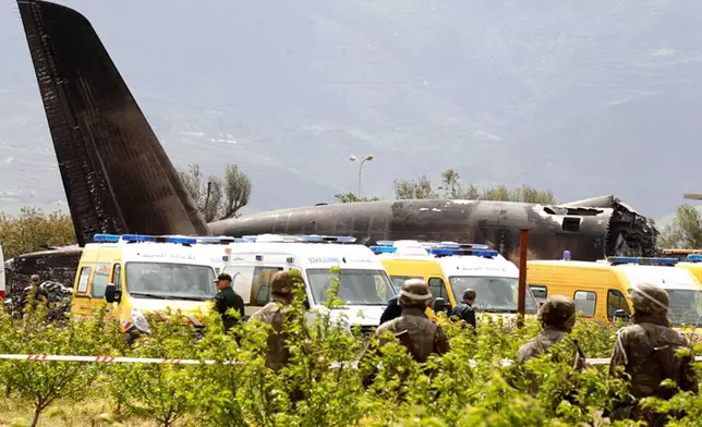 Algerian soldiers watch the military plane after it crashed in Boufarik, near the Algerian capital, Algiers, Wednesday, April 11, 2018. Algerian emergency services say 181 people have been killed in a military plane crash and some survivors have been rescued. (AP Photo/Anis Belghoul)