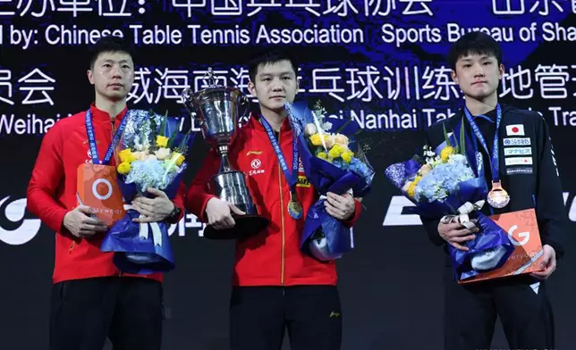 Gold medalist Fan Zhendong (C) of China, silver medalist Ma Long (L) of China and bronze medalist Harimoto Tomokazu of Japan pose during the awarding ceremony for the men's singles competition at 2020 ITTF Men's World Cup in Weihai, east China's Shandong Province, Nov. 15, 2020.