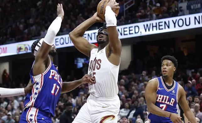 Cleveland Cavaliers guard Donovan Mitchell (45) shoots against Philadelphia 76ers guard Buddy Hield (17) and guard Kyle Lowry (7) during the second half of an NBA basketball game Friday, March 29, 2024, in Cleveland. (AP Photo/Ron Schwane)