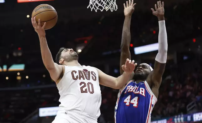 Cleveland Cavaliers forward Georges Niang (20) shoots against Philadelphia 76ers forward Paul Reed (44) during the second half of an NBA basketball game Friday, March 29, 2024, in Cleveland. (AP Photo/Ron Schwane)