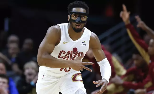 Cleveland Cavaliers guard Donovan Mitchell reacts after making a 3-point basket against the Philadelphia 76ers during the first half of an NBA basketball game Friday, March 29, 2024, in Cleveland. (AP Photo/Ron Schwane)