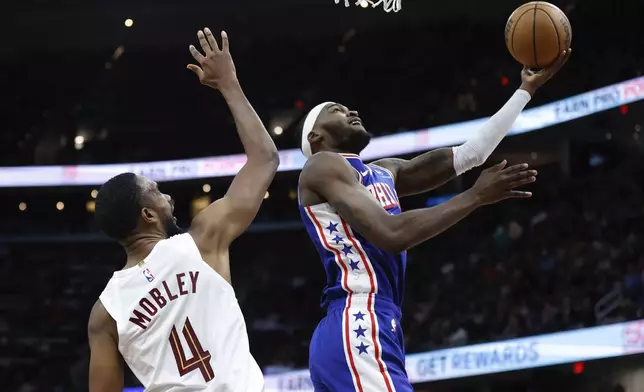 Philadelphia 76ers forward Paul Reed shoots against Cleveland Cavaliers forward Evan Mobley (4) during the first half of an NBA basketball game Friday, March 29, 2024, in Cleveland. (AP Photo/Ron Schwane)