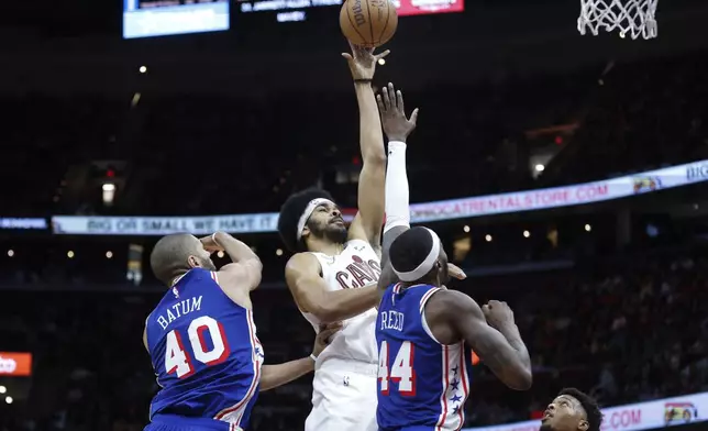 Cleveland Cavaliers center Jarrett Allen shoots against Philadelphia 76ers forward Paul Reed (44) and forward Nicolas Batum (40) during the second half of an NBA basketball game Friday, March 29, 2024, in Cleveland. (AP Photo/Ron Schwane)