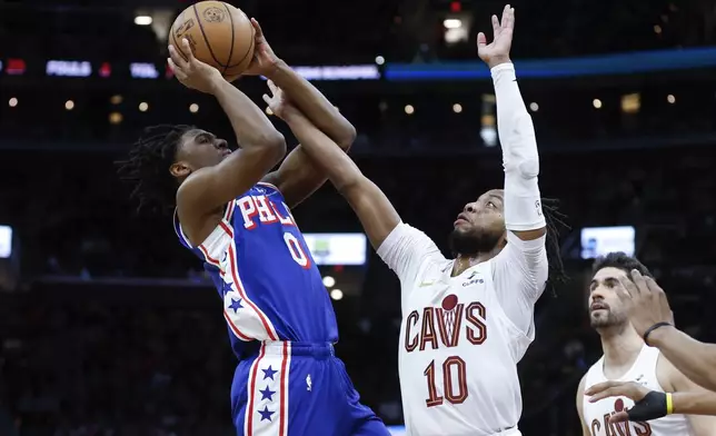 Philadelphia 76ers guard Tyrese Maxey (0) shoots against Cleveland Cavaliers guard Darius Garland (10) during the first half of an NBA basketball game Friday, March 29, 2024, in Cleveland. (AP Photo/Ron Schwane)