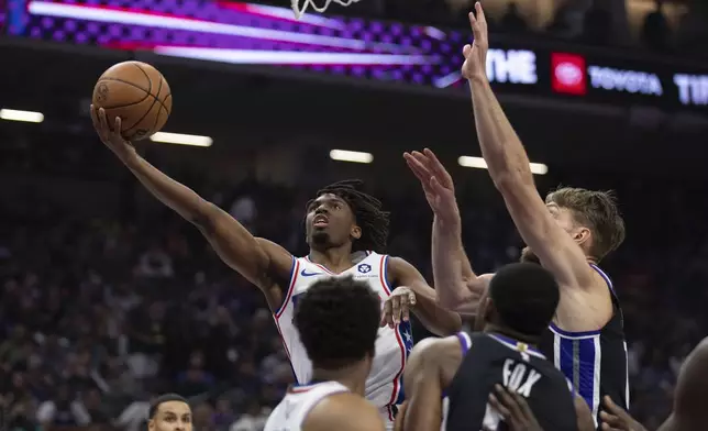 Philadelphia 76ers guard Tyrese Maxey drives to the basket past Sacramento Kings forward Domantas Sabonis, right, in the first half of an NBA basketball game in Sacramento, Calif., Monday, March 25, 2024. (AP Photo/José Luis Villegas)