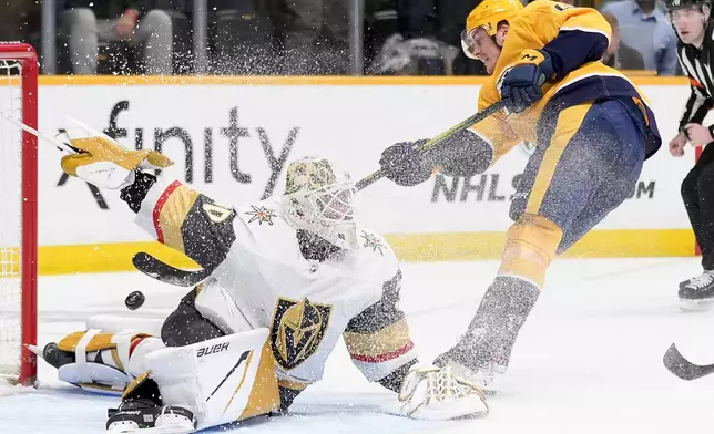 Vegas Golden Knights goaltender Jiri Patera (30) deflects a shot on goal by Nashville Predators defenseman Tyson Barrie, right, during the second period of an NHL hockey game Tuesday, March 26, 2024, in Nashville, Tenn. (AP Photo/George Walker IV)