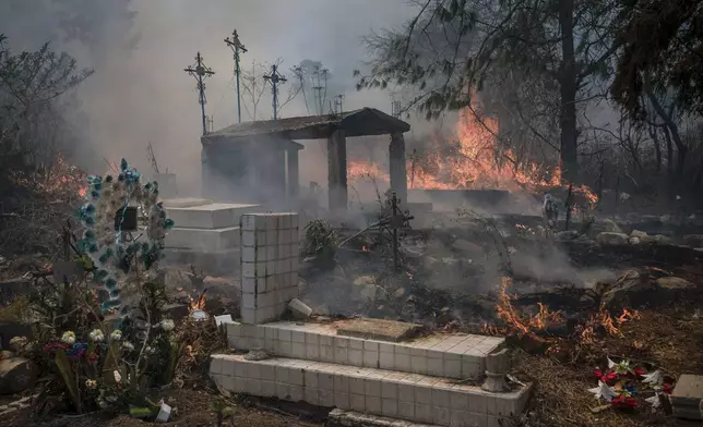 Wildfires burn parts of a cemetery in Nogales, Mexico, Monday, March 25, 2024. Emergency crews are working to contain wildfires burning across parts of the High Mountains area in Veracruz state. (AP Photo/Felix Marquez)