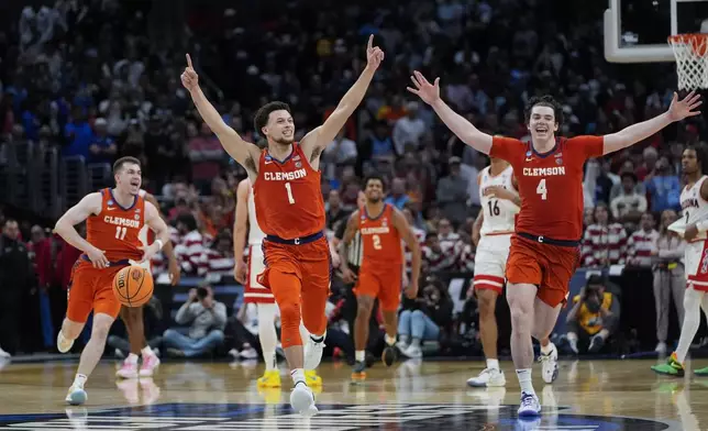 Clemson guard Chase Hunter (1) guard Joseph Girard III (11) and forward Ian Schieffelin (4) celebrate after a win over Arizona in a Sweet 16 college basketball game in the NCAA tournament Thursday, March 28, 2024, in Los Angeles. (AP Photo/Ryan Sun)