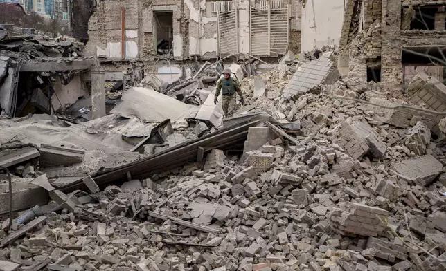 A Ukrainian serviceman inspects the damage to a building at the Pecherskyi district, after a Russian air attack in Kyiv, Ukraine, Monday March 25, 2024. Five people were injured in the strike, two were hospitalized. (AP Photo/Vadim Ghirda)
