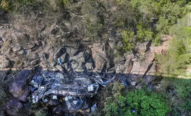 The wreckage off a bus lays in a ravine a day after it plunged off a bridge on the Mmamatlakala mountain pass between Mokopane and Marken, around 300km (190 miles) north of Johannesburg, South Africa, Friday, March 29, 2024. A bus carrying worshippers on a long-distance trip from Botswana to an Easter weekend church gathering in South Africa plunged off a bridge on a mountain pass Thursday and burst into flames as it hit the rocky ground below, killing at least 45 people, authorities said. The only survivor was an 8-year-old child who was receiving medical attention for serious injuries. (AP Photo/Themba Hadebe)