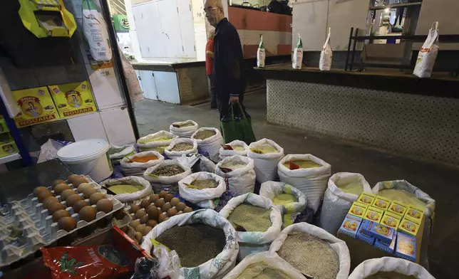 A man stands by food bags in a market near Algiers, Tuesday, March 26, 2024. As Muslim-majority countries reckon with increased demand throughout Islam's holy month of Ramadan, is trying to flood new markets with pantry staples to stave off shortages that can cause prices to rise. (AP Photo/Anis Belghoul)