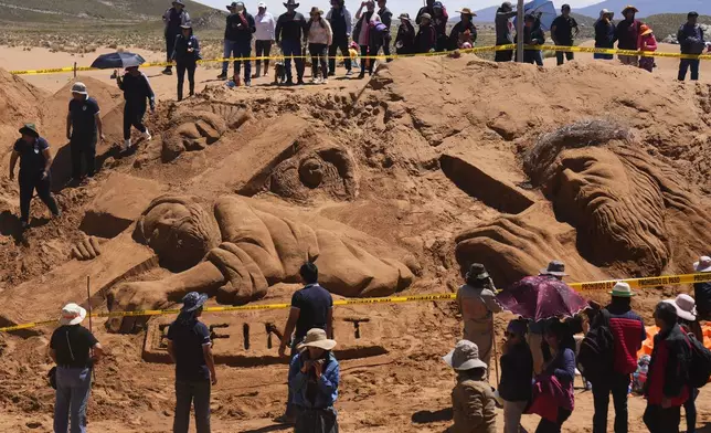 People gather round sand sculptures depicting Jesus Christ on a cross as part of Holy Week celebrations, in Los Arenales de Cochiraya, on the outskirts of Oruro, Bolivia, Good Friday, March 29, 2024. Artists gathered for the annual Holy Week event in the highland region, building sand sculptures based on Bible stories. (AP Photo/Juan Karita)