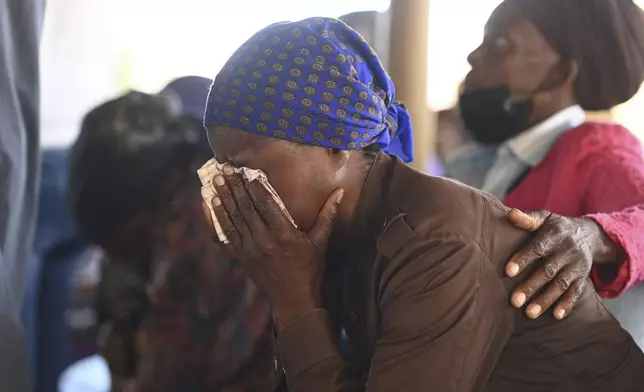 Family members of the bus crash victims gather at the ZCC Church, where victims used for church services in the Molepolole village near Gaborone, Botswana, Friday, March 29, 2024. A bus carrying Easter pilgrims from Botswana to Moria in South Africa crashed en route in Mokopane, South Africa, claiming the lives of some 45 people. An 8-year-old survived. (AP Photo)