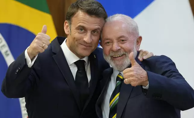 Brazilian President Luiz Inacio Lula da Silva, right, and France's President Emmanuel Macron pose for photos at Planalto presidential palace in Brasilia, Brazil, Thursday, March 28, 2024. (AP Photo/Eraldo Peres)