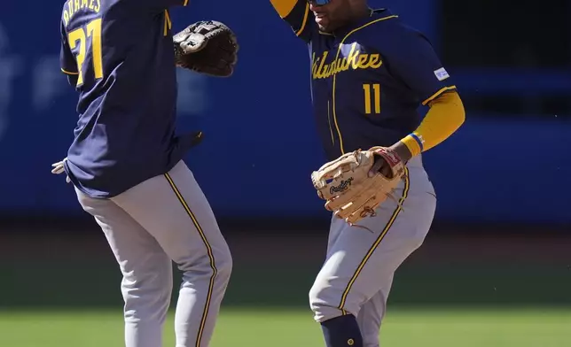 Milwaukee Brewers' Willy Adames, left, celebrates with Jackson Chourio, right, after a baseball game against the New York Mets Friday, March 29, 2024, in New York. The Brewers won 3-1. (AP Photo/Frank Franklin II)