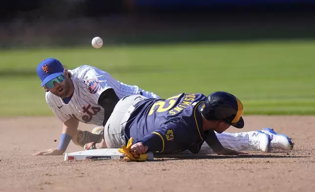 New York Mets' Jeff McNeil (1) loses control of the ball as Milwaukee Brewers' Rhys Hoskins (12) slides into him during the eighth inning of a baseball game Friday, March 29, 2024, in New York. (AP Photo/Frank Franklin II)