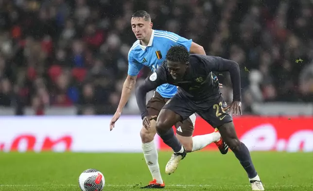 England's Kobbie Mainoo, right, is challenged by Belgium's Timothy Castagne during an international friendly soccer match between England and Belgium at Wembley Stadium, in London, Tuesday, March 26, 2024. (AP Photo/Kirsty Wigglesworth)