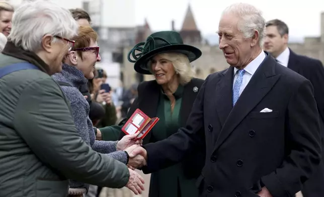 Britain's King Charles III and Queen Camilla greet people after attending the Easter Matins Service at St. George's Chapel, Windsor Castle, England, Sunday, March 31, 2024. (Hollie Adams/Pool Photo via AP)