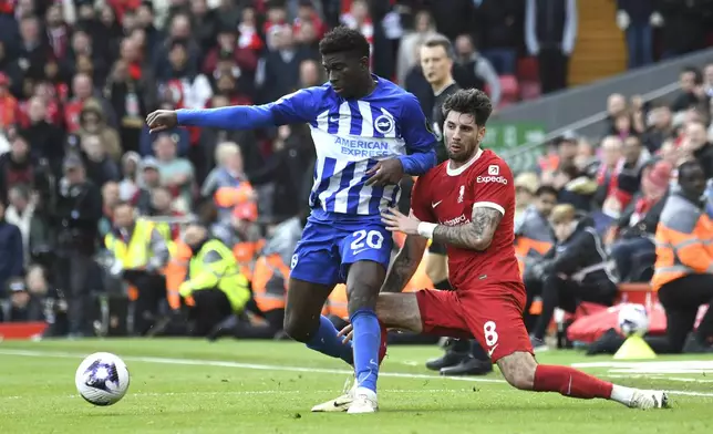 Brighton's Carlos Baleba, left, challenges for the ball with Liverpool's Dominik Szoboszlai during the English Premier League soccer match between Liverpool and Brighton and Hove at Anfield Stadium in Liverpool, England, Sunday, March 31, 2024. (AP Photo/Rui Vieira)