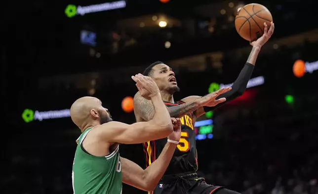 Atlanta Hawks guard Dejounte Murray (5) goes in for a shot as Boston Celtics guard Derrick White (9) defends during the first half of an NBA basketball game Thursday, March 28, 2024, in Atlanta. (AP Photo/John Bazemore)