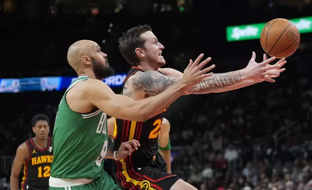 Atlanta Hawks guard Garrison Mathews (25) loses control of the ball as he drives against Boston Celtics guard Derrick White (9) during the first half of an NBA basketball game Thursday, March 28, 2024, in Atlanta. (AP Photo/John Bazemore)