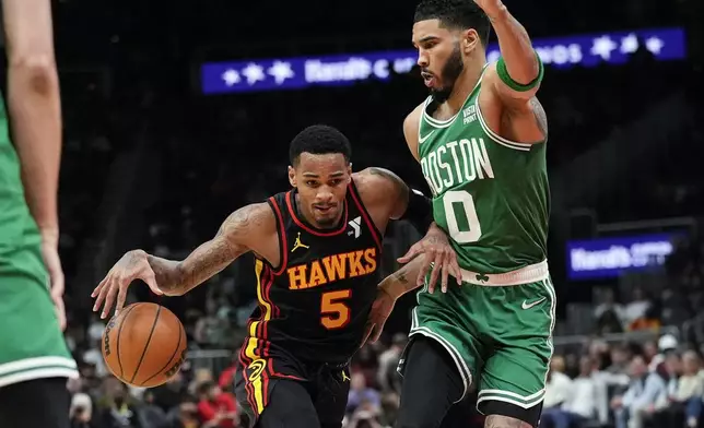 Atlanta Hawks guard Dejounte Murray (5) drives against Boston Celtics forward Jayson Tatum (0) during the first half of an NBA basketball game Thursday, March 28, 2024, in Atlanta. (AP Photo/John Bazemore)