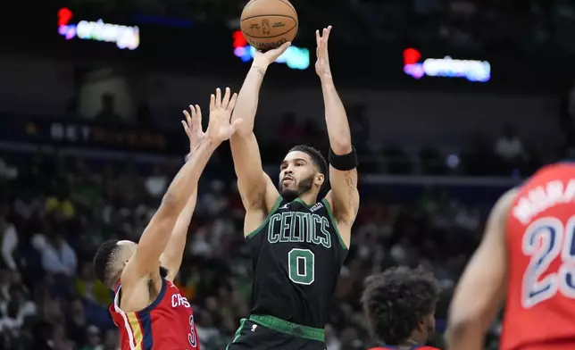 Boston Celtics forward Jayson Tatum (0) shoots against New Orleans Pelicans guard CJ McCollum in the second half of an NBA basketball game in New Orleans, Saturday, March 30, 2024. The Celtics won 104-92. (AP Photo/Gerald Herbert)