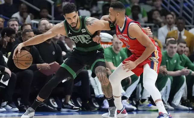 Boston Celtics forward Jayson Tatum works the ball against New Orleans Pelicans guard CJ McCollum in the first half of an NBA basketball game in New Orleans, Saturday, March 30, 2024. (AP Photo/Gerald Herbert)