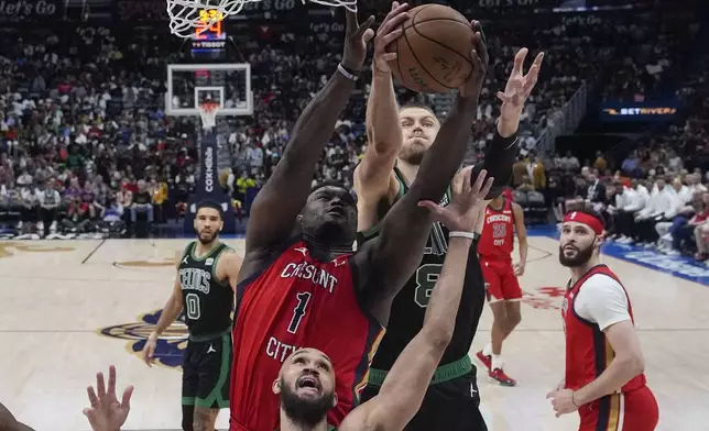 New Orleans Pelicans forward Zion Williamson (1) battles for the ball with Boston Celtics center Kristaps Porzingis (8) and guard Derrick White in the second half of an NBA basketball game in New Orleans, Saturday, March 30, 2024. The Celtics won 104-92. (AP Photo/Gerald Herbert)