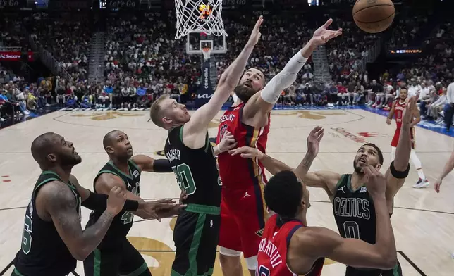 New Orleans Pelicans center Jonas Valanciunas (17) and guard Trey Murphy III battle for a rebound against Boston Celtics forward Sam Hauser (30), forward Jayson Tatum (0), center Al Horford and forward Xavier Tillman, left, in the second half of an NBA basketball game in New Orleans, Saturday, March 30, 2024. The Celtics won 104-92. (AP Photo/Gerald Herbert)