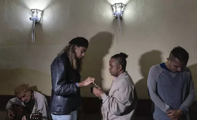 Mario Amilcar, center left, prepares to give Holy Communion to a fellow congregant during a service at the Metropolitan Community Church, an LGBTQ+ inclusive house of worship, in Matanzas, Cuba, Friday, Feb. 2, 2024. In recent years, the communist-run island barred anti-gay discrimination, and a 2022 government-backed “family law” allowed same-sex couples the right to marry and adopt. (AP Photo/Ramon Espinosa)