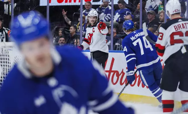 New Jersey Devils center Nico Hischier (13) celebrates after scoring a goal against the Toronto Maple Leafs during the first period of an NHL hockey game in Toronto on Tuesday, March 26, 2024. (Cole Burston/The Canadian Press via AP)