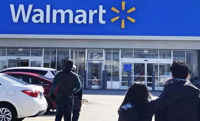 FILE - Shoppers walk to a Walmart in Vernon Hills, Ill., Tuesday, March 28, 2023. Don't count on a favorite store being open on Easter Sunday. Several stores will be closed March 31, 2024, in observance of the holiday. (AP Photo/Nam Y. Huh, File)