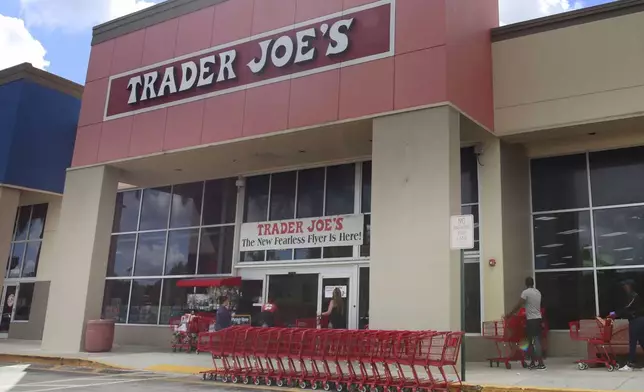 FILE - People stand in line waiting to enter Trader Joe's to buy groceries in Pembroke Pines, Fla., on March 24, 2020. Don't count on a favorite store being open on Easter Sunday. Several stores will be closed March 31, 2024, in observance of the holiday. (AP Photo/Brynn Anderson, File)