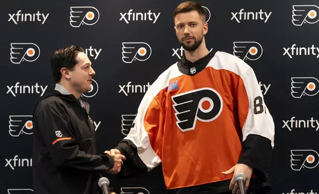 Philadelphia Flyers' Ivan Fedotov, right, shakes hands with general manager Daniel Briere during an NHL hockey press conference, Friday, March 29, 2024, in Voorhees, N.J. (AP Photo/Chris Szagola)