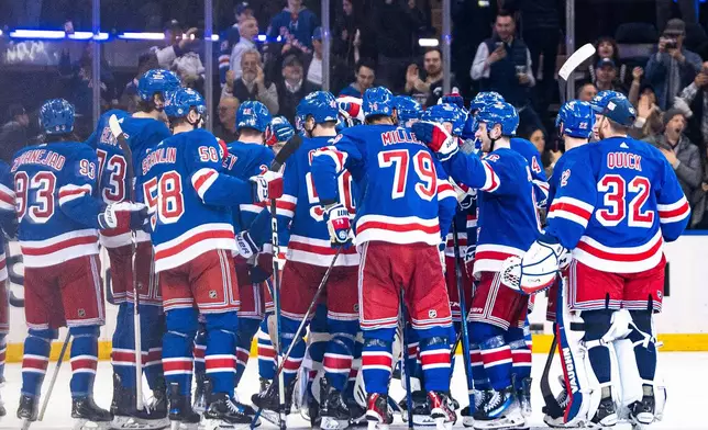 New York Rangers players gather on the ice after Adam Fox's overtime goal against the Philadelphia Flyers in an NHL hockey game Tuesday, March 26, 2024 in New York. (AP Photo/Peter K. Afriyie)