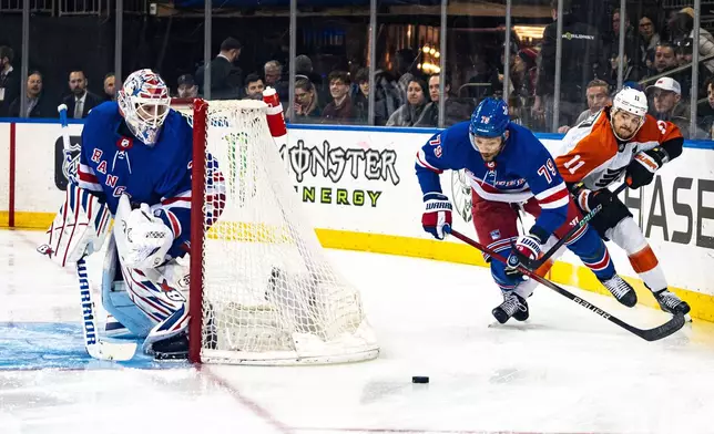 New York Rangers defenseman K'Andre Miller (79) and Philadelphia Flyers right wing Travis Konecny (11) chase the puck during the first period of an NHL hockey game Tuesday, March 26, 2024, in New York. (AP Photo/Peter K. Afriyie)