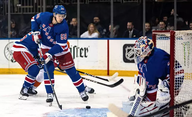 New York Rangers defenseman Brandon Scanlin (58) attempts to clear the puck during the first period of the team's NHL hockey game against the Philadelphia Flyers on Tuesday, March 26, 2024, in New York. (AP Photo/Peter K. Afriyie)