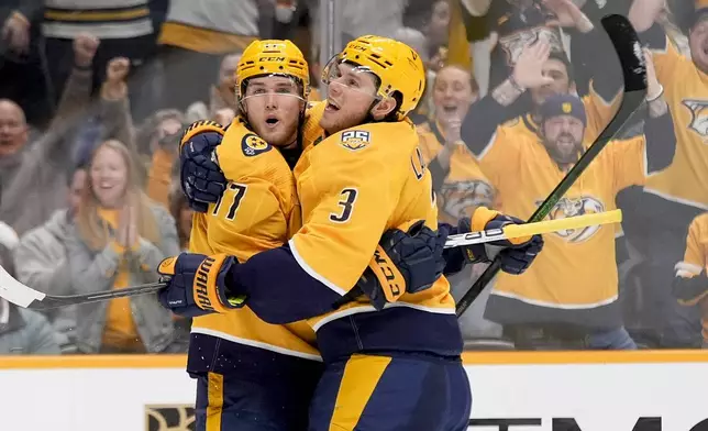 Nashville Predators center Mark Jankowski (17) celebrates his goal with defenseman Jeremy Lauzon (3) during the second period of an NHL hockey game against the Vegas Golden Knights, Tuesday, March 26, 2024, in Nashville, Tenn. (AP Photo/George Walker IV)