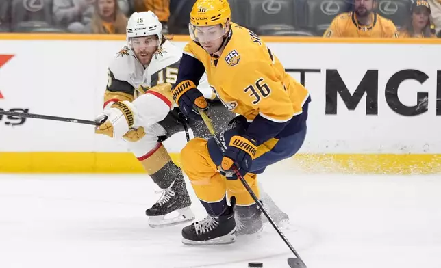 Nashville Predators left wing Cole Smith (36) skates the puck past Vegas Golden Knights defenseman Noah Hanifin (15) during the second period of an NHL hockey game Tuesday, March 26, 2024, in Nashville, Tenn. (AP Photo/George Walker IV)