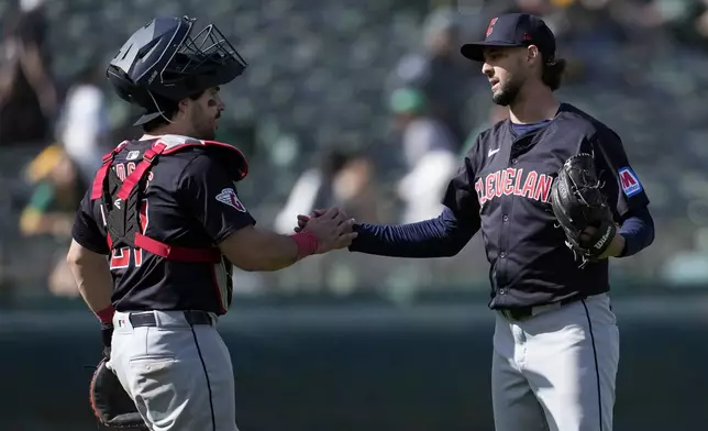 Cleveland Guardians catcher Austin Hedges, left, celebrates with pitcher Tyler Beede after the Guardians defeated the Oakland Athletics in a baseball game in Oakland, Calif., Saturday, March 30, 2024. (AP Photo/Jeff Chiu)